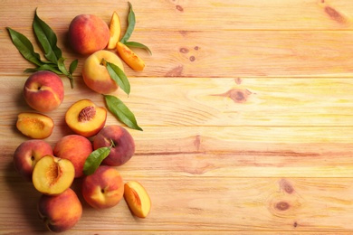 Fresh sweet peaches on wooden table, flat lay. Space for text