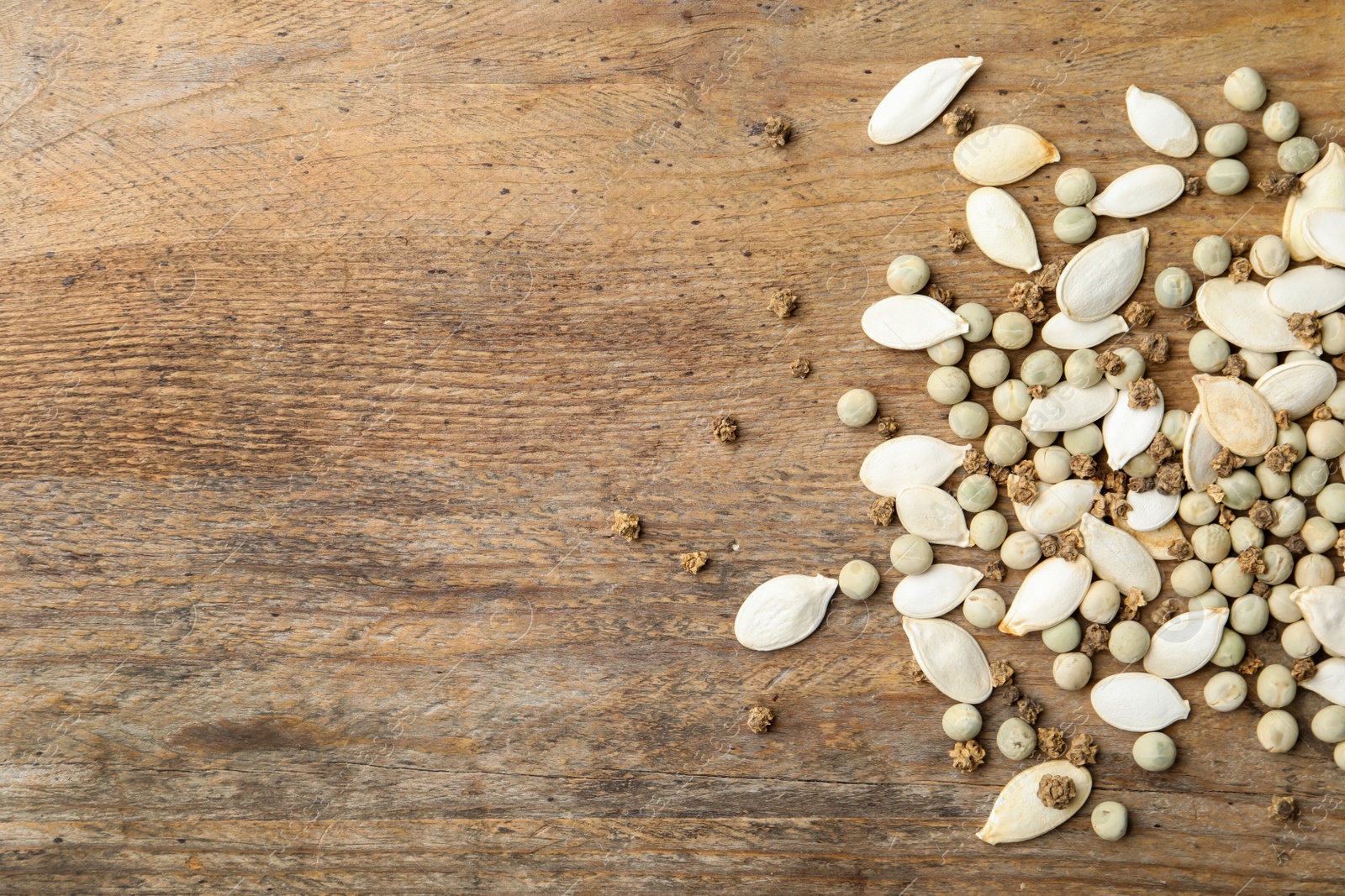 Photo of Mixed vegetable seeds on wooden background, flat lay. Space for text