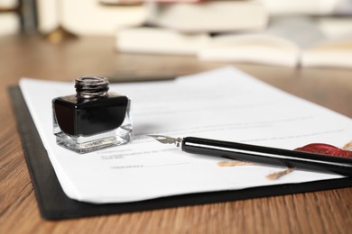 Photo of Document, fountain pen and inkwell on wooden table, closeup. Notary contract