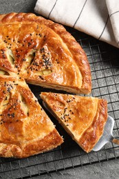 Taking piece of delicious homemade pie and server on grey table, top view