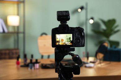 Beauty blogger's workplace. Cosmetic products on table indoors, focus on camera