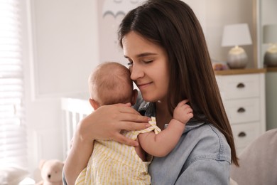 Happy young mother with her cute baby at home