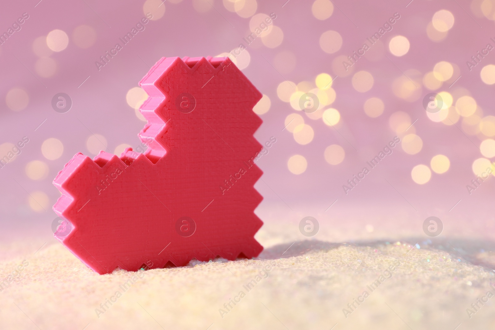 Photo of Decorative red heart on glitter against blurred lights, closeup