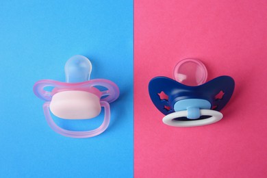 Photo of Baby pacifiers on color background, flat lay