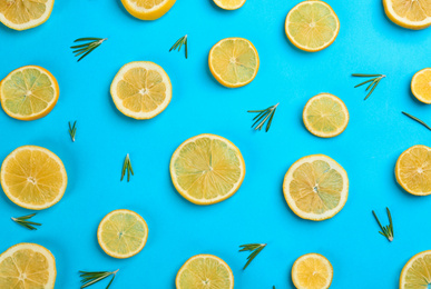 Photo of Lemonade layout with juicy lemon slices and rosemary on blue background, top view