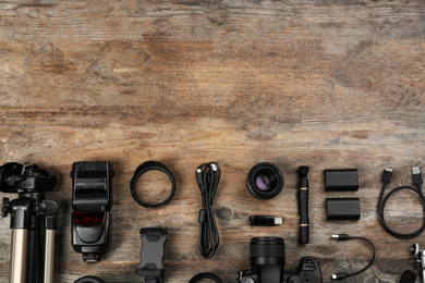 Photo of Flat lay composition with camera and video production equipment on wooden table. Space for text