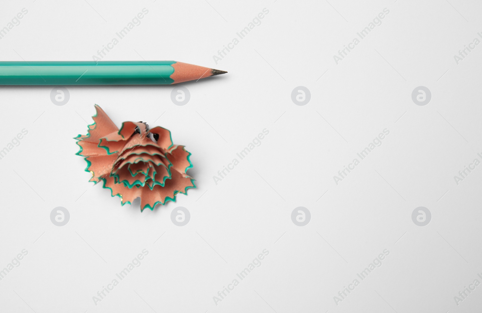 Photo of Graphite pencil and shavings on white background, space for text