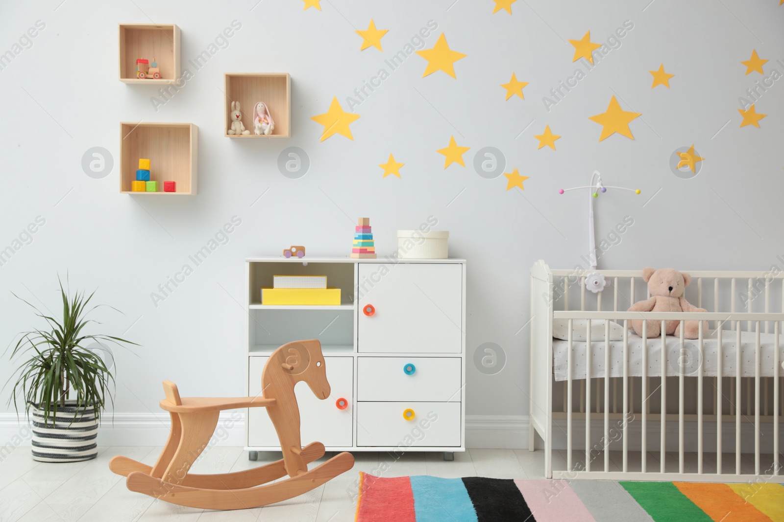 Photo of Stylish baby room interior with crib and toys