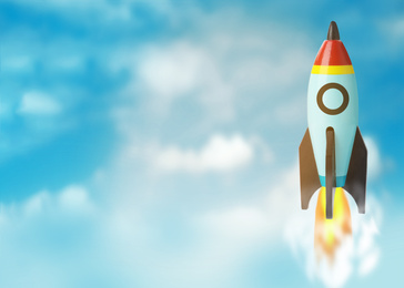 Image of Business startup concept. Modern rocket flying in blue sky, space for text