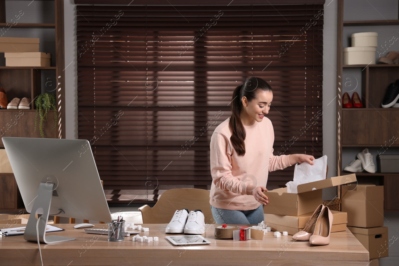 Photo of Shoes seller working at table in office. Online store