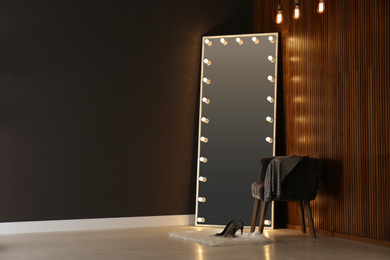 Modern mirror with lamps in room interior. Space for text