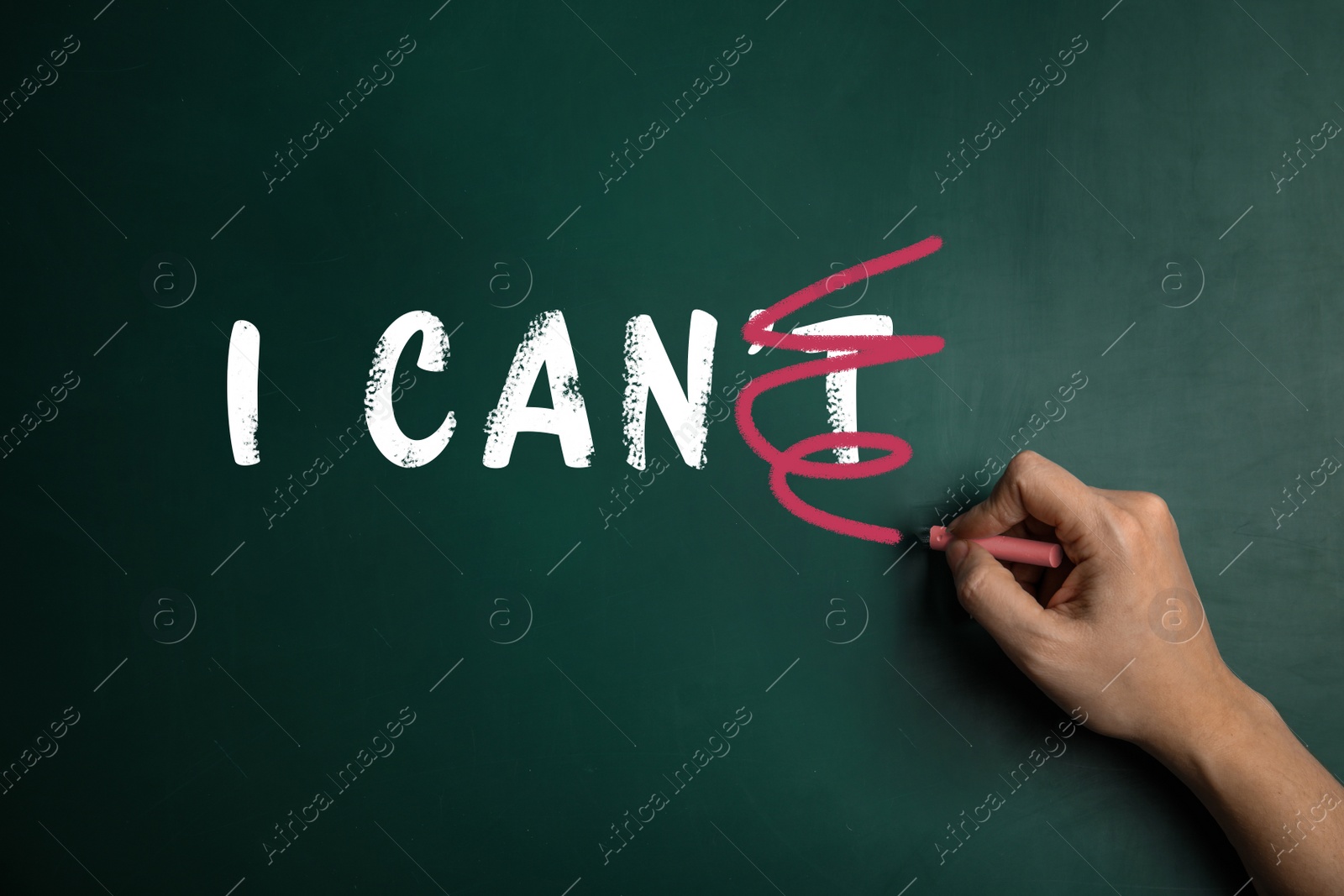 Image of Woman crossed out letter T in phrase I CAN'T written on green chalkboard, closeup. Motivation and positivity