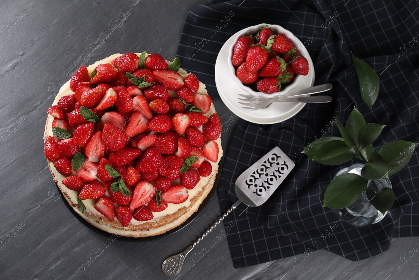 Photo of Tasty cake with fresh strawberries and mint served on table, flat lay