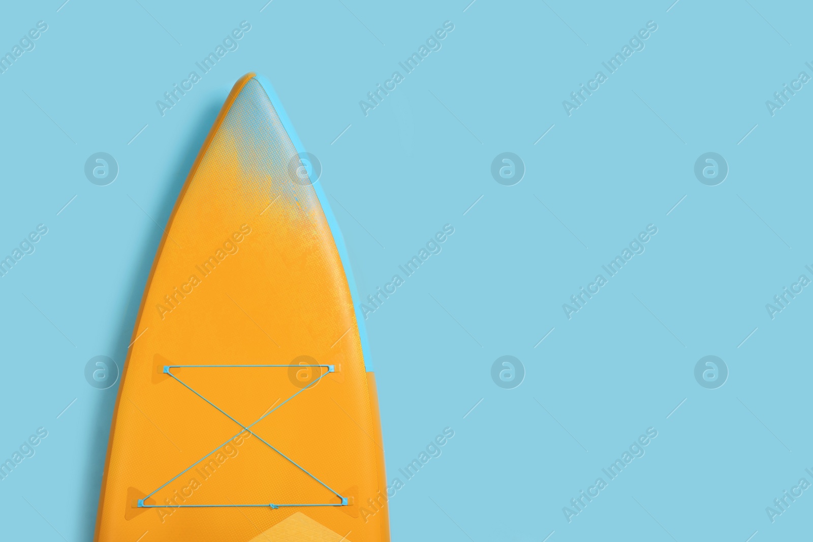 Photo of One SUP board on light blue background, top view with space for text. Water sport