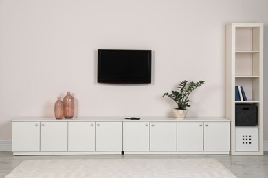 Photo of Modern TV set mounted on wall in living room