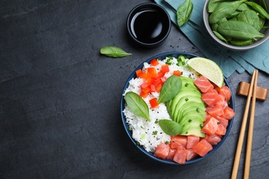 Delicious poke bowl with salmon, spinach and avocado served on black table, flat lay. Space for text