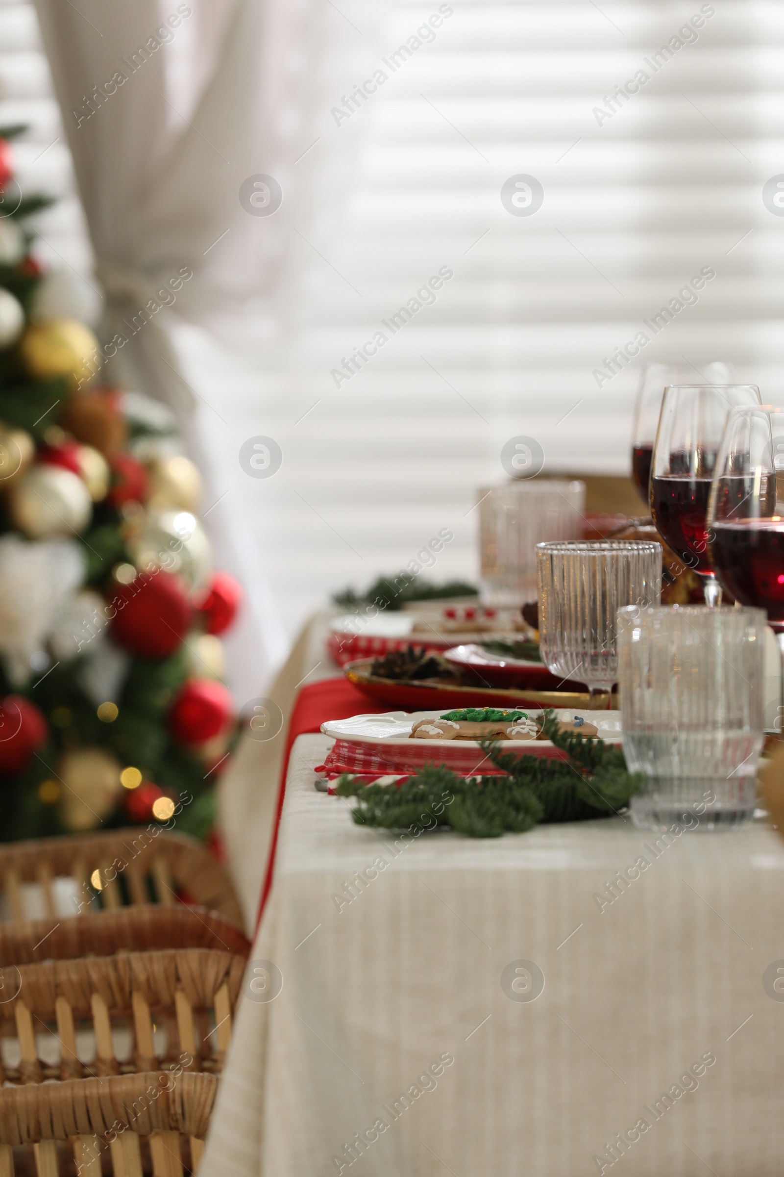 Photo of Festive dinner with delicious gingerbread cookie and wine on table indoors. Christmas Eve celebration