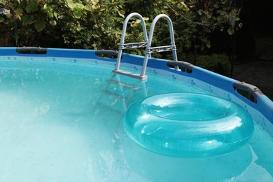 Photo of Inflatable ring floating on water in above ground swimming pool outdoors