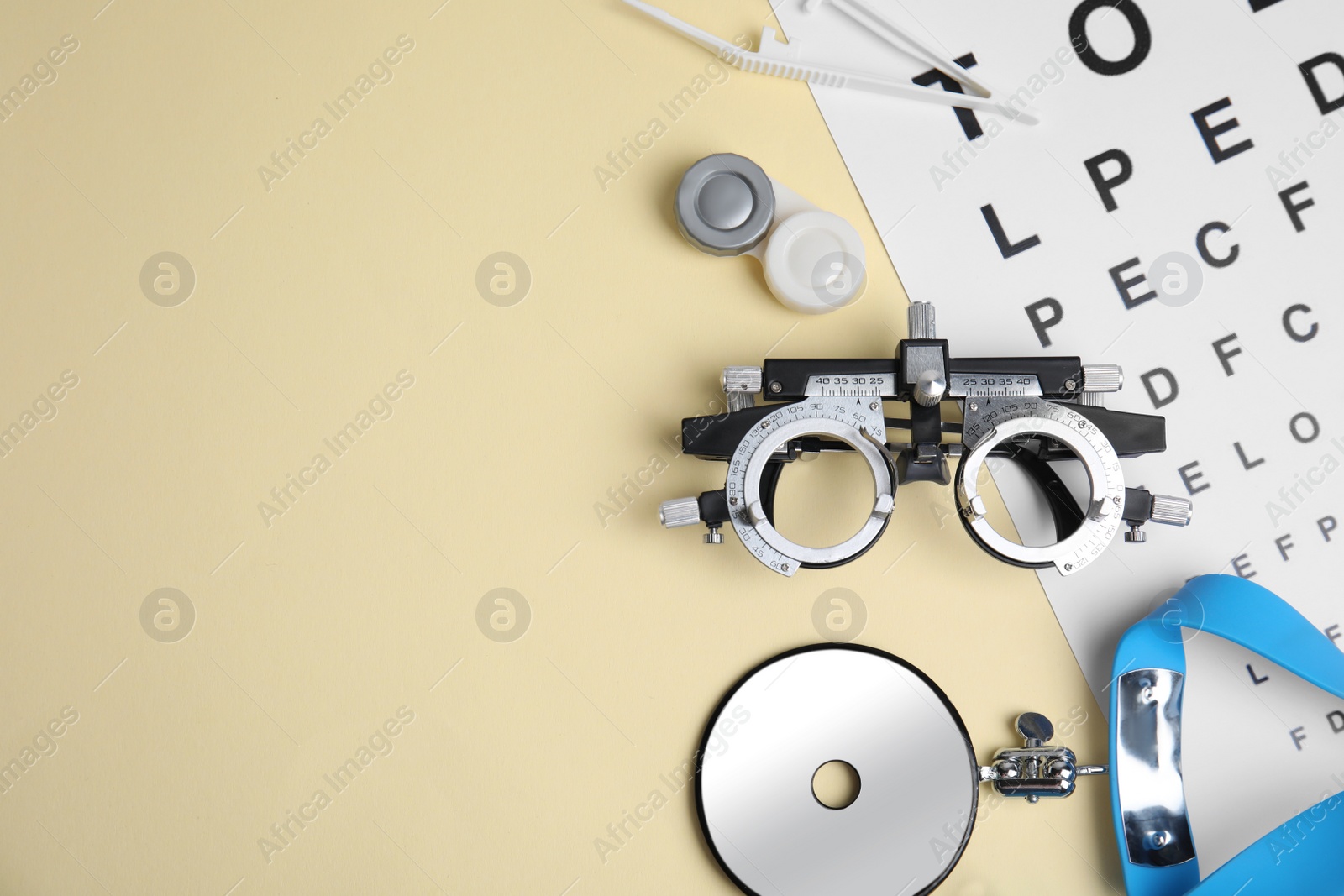 Photo of Different ophthalmologist tools on beige background, flat lay. Space for text