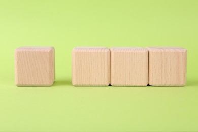 International Organization for Standardization. Wooden cubes with check mark and abbreviation ISO on light green background
