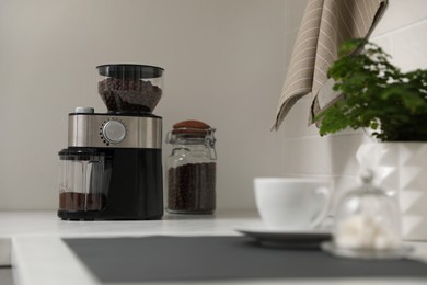Modern coffee grinder on counter in kitchen