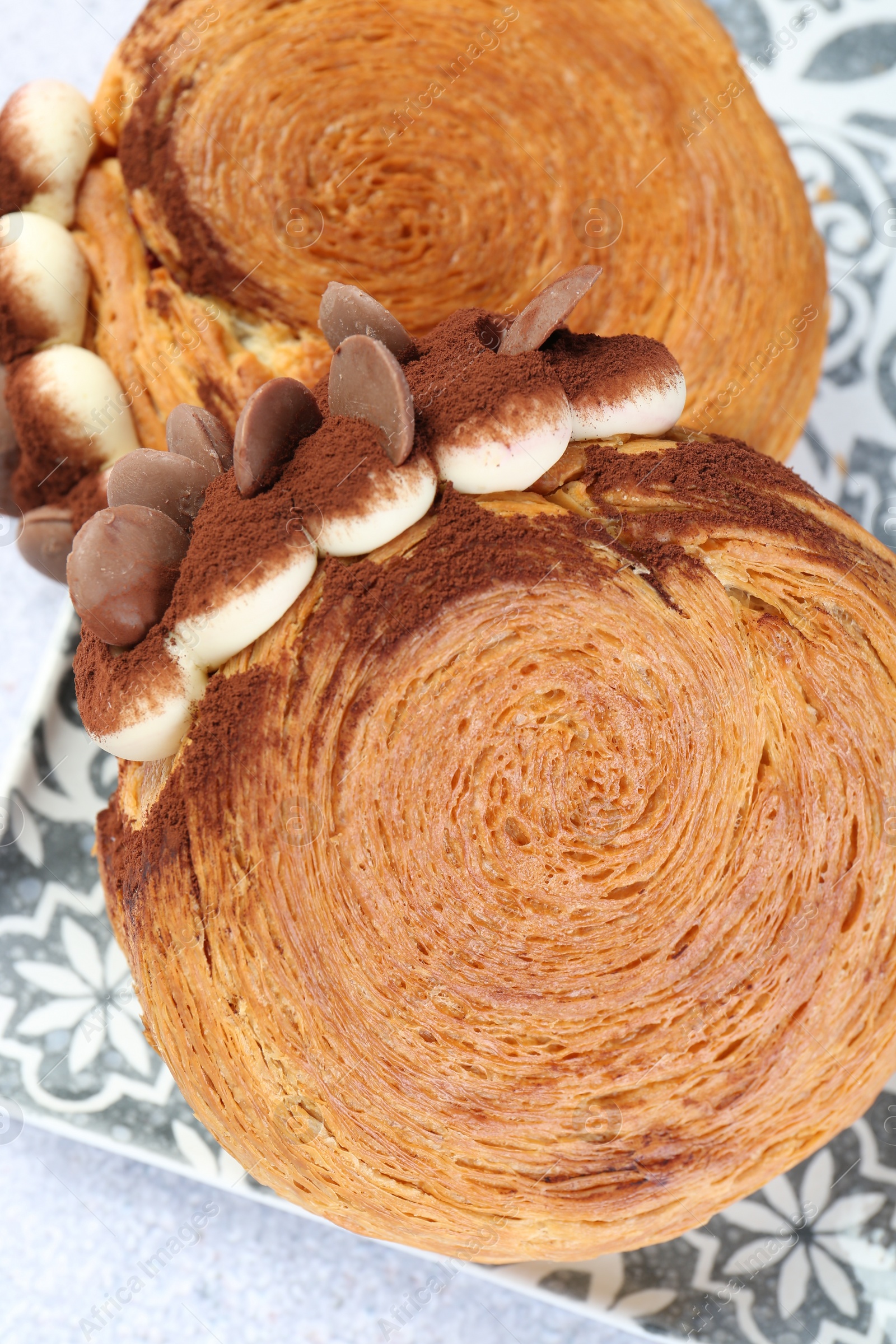 Photo of Supreme croissants with chocolate chips and cream on light table, above view. Tasty puff pastry