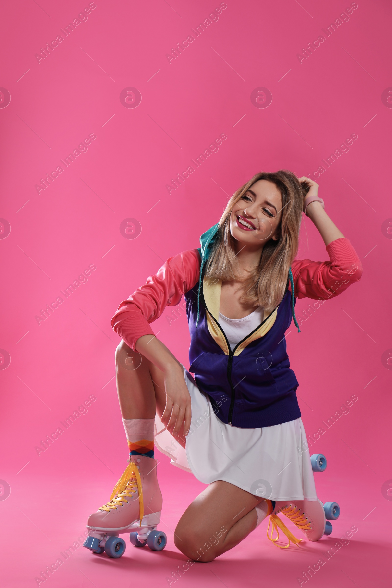 Photo of Young woman with retro roller skates on color background