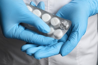 Photo of Doctor taking pill out from blister pack, closeup