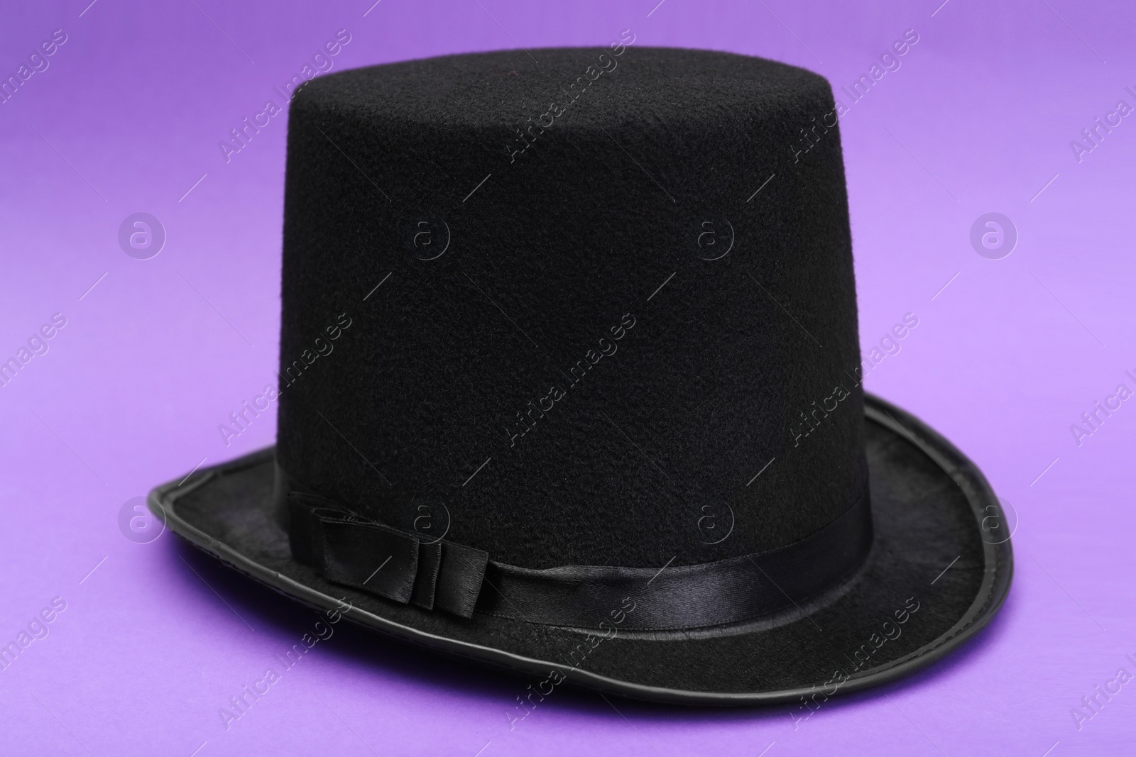 Photo of One magician top hat on violet background