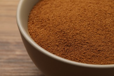 Photo of Bowl of chicory powder on wooden table, closeup