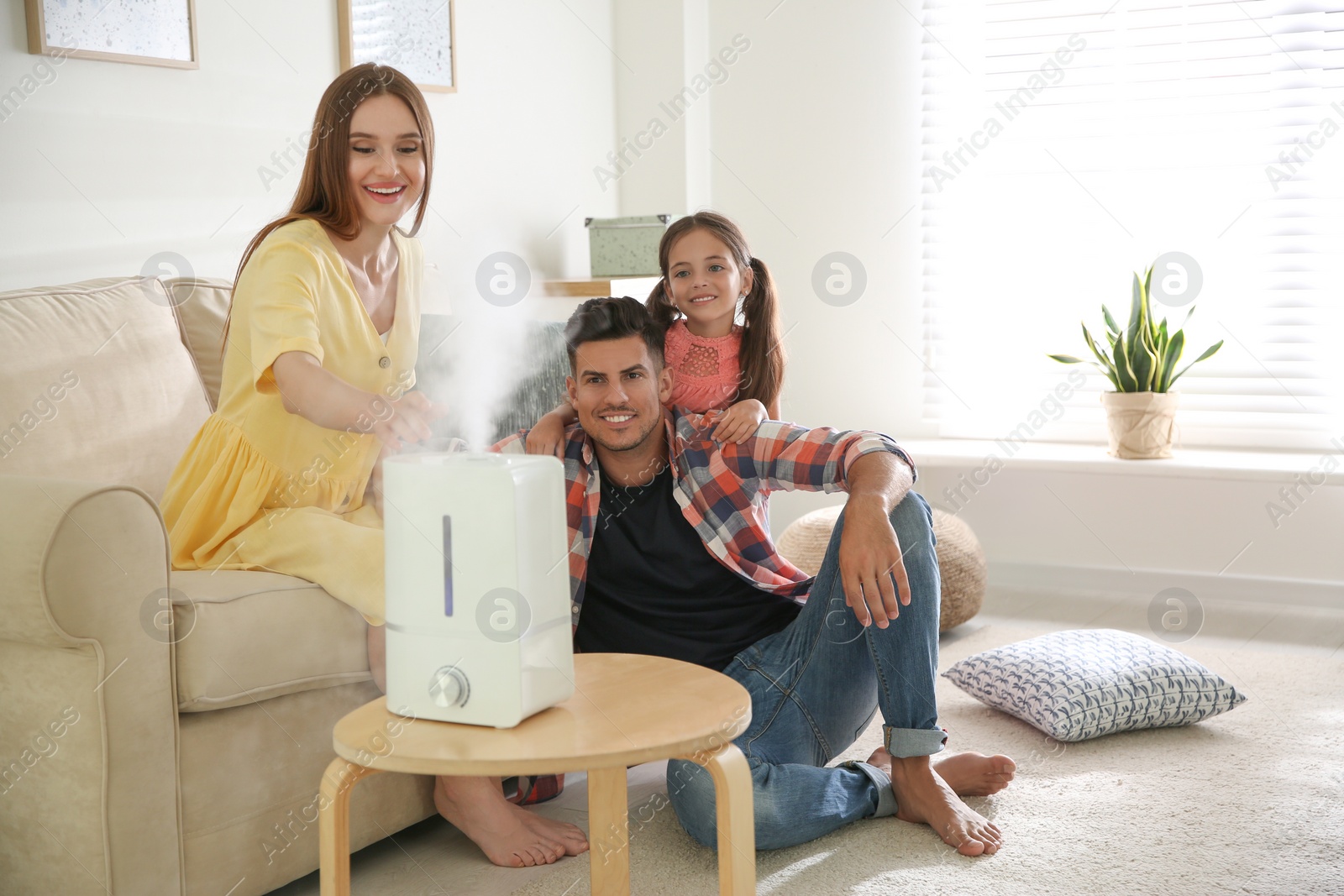 Photo of Family near modern air humidifier at home