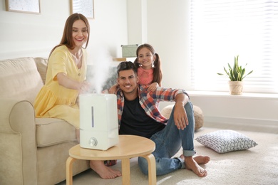 Family near modern air humidifier at home