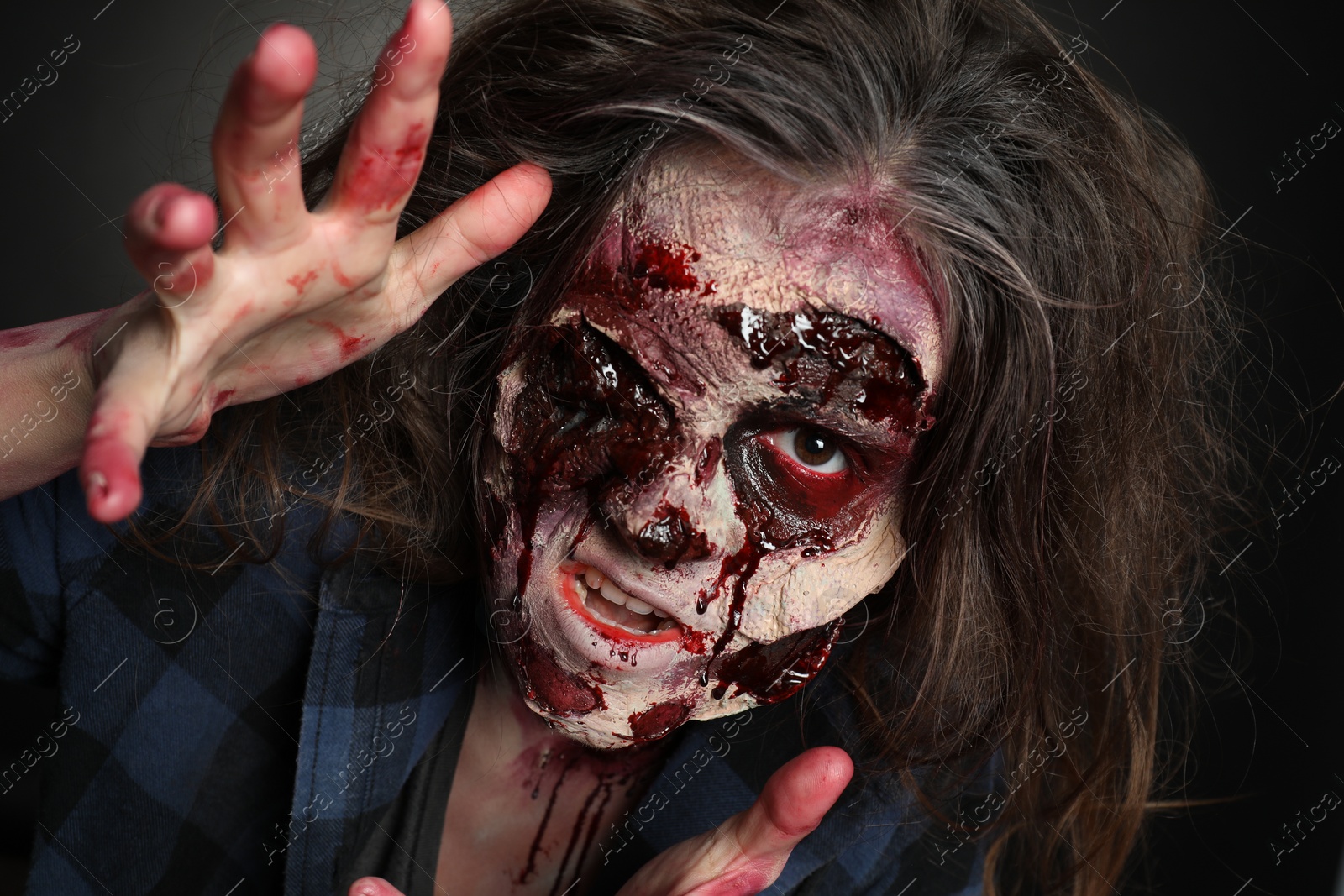 Photo of Scary zombie on dark background, closeup. Halloween monster