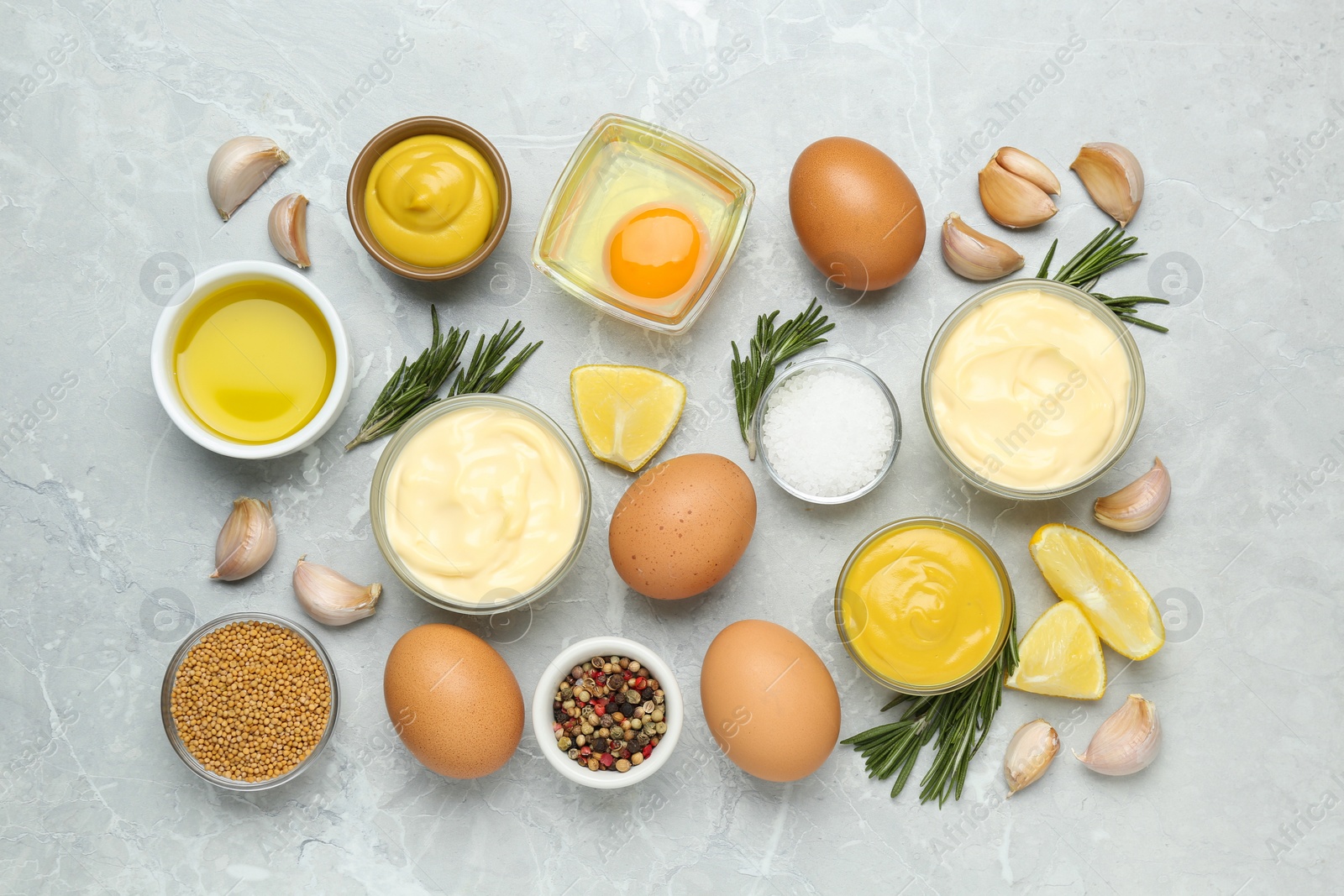 Photo of Delicious homemade mayonnaise, spices and ingredients on grey table, flat lay