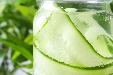 Photo of Jar of fresh cucumber water on blurred background, closeup