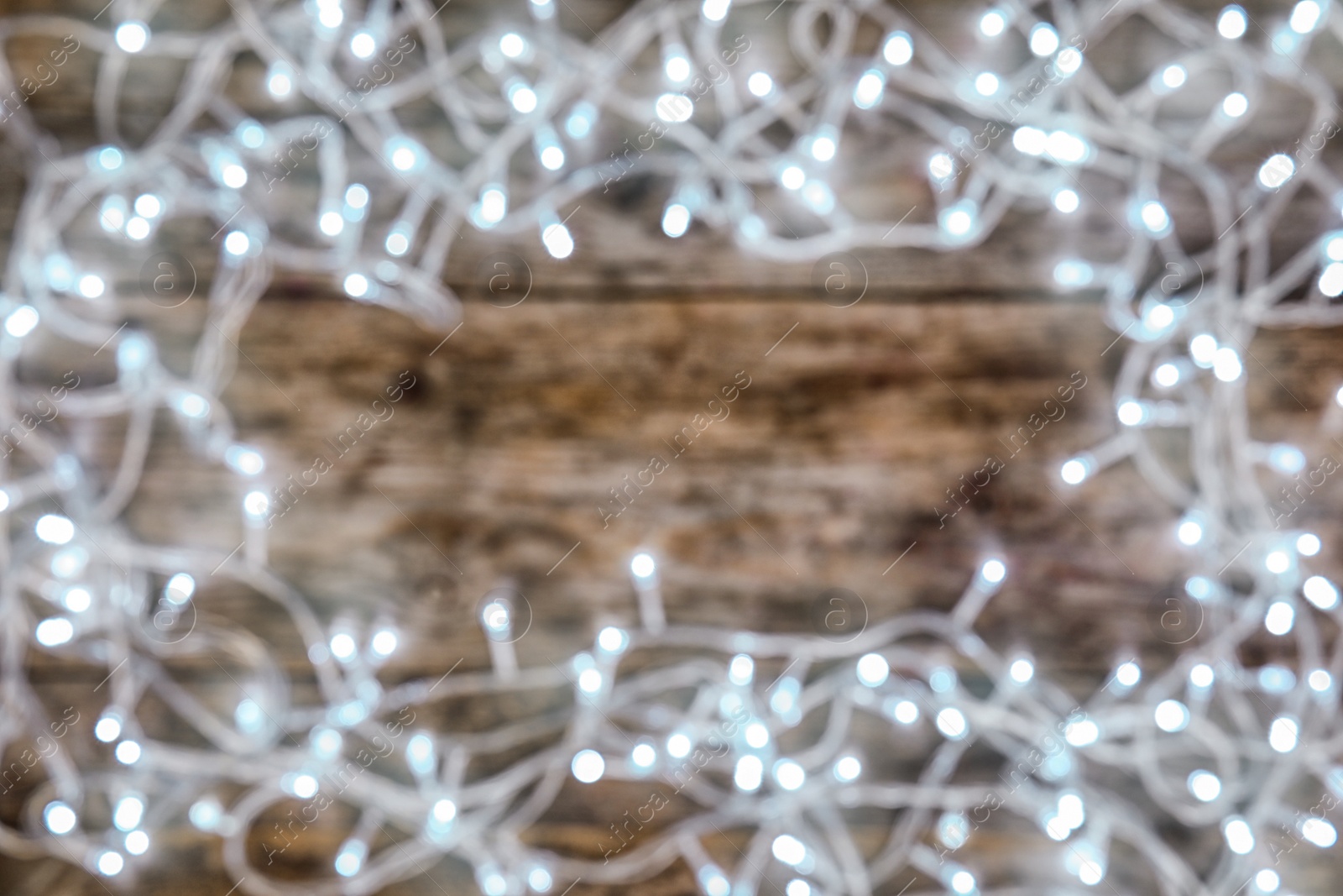 Photo of Blurred view of glowing Christmas lights on color background, top view