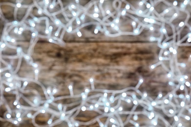 Photo of Blurred view of glowing Christmas lights on color background, top view