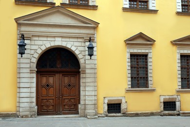 Photo of View of house with beautiful arched wooden door and grated windows. Exterior design