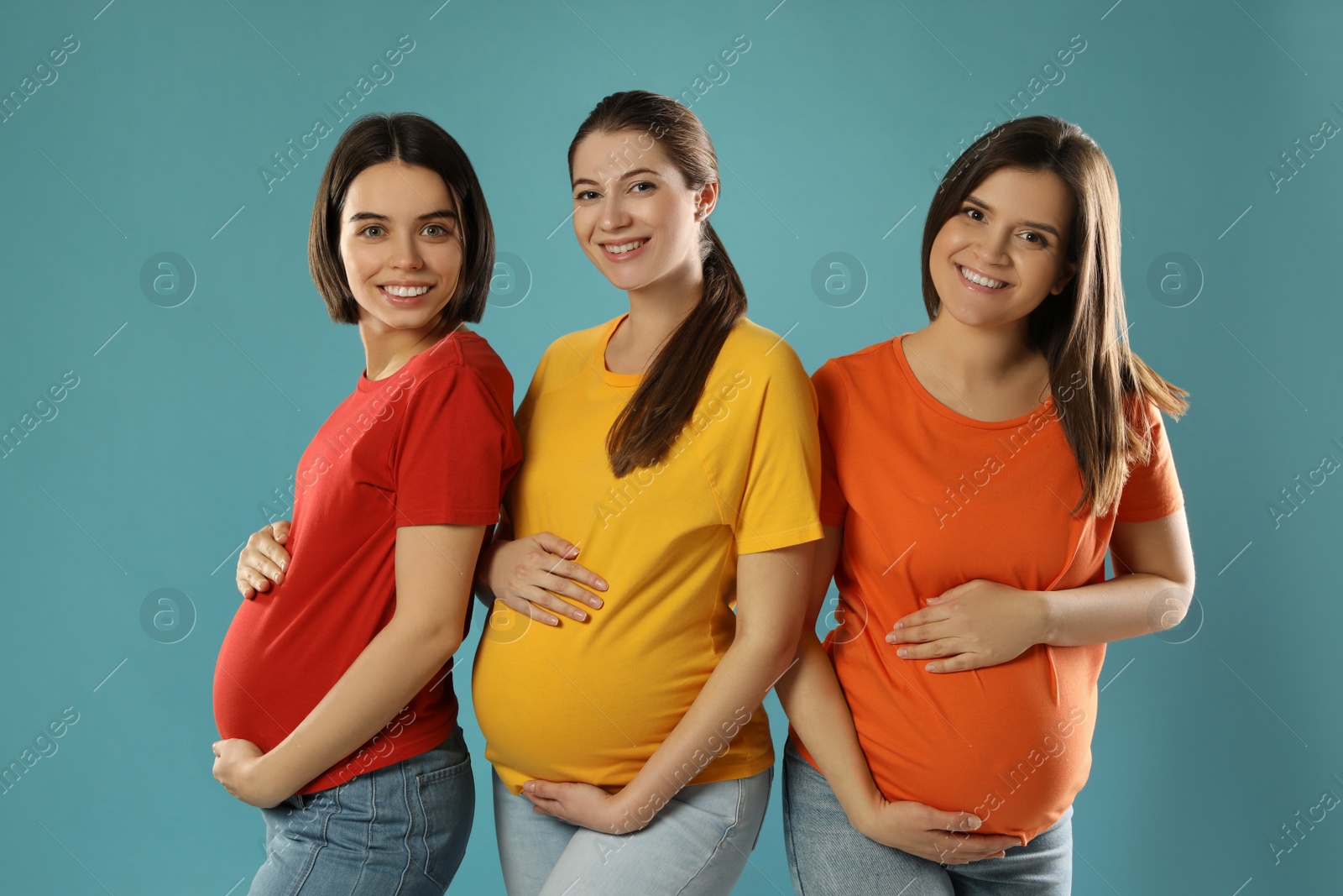 Photo of Happy young pregnant women on turquoise background