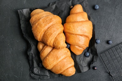 Tasty croissants on dark background, top view