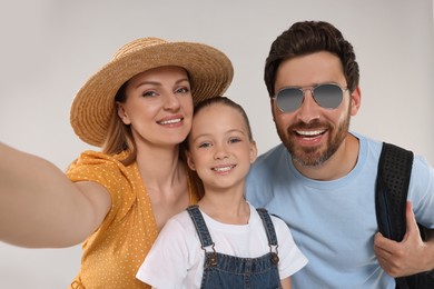 Photo of Happy family taking selfie on light grey background