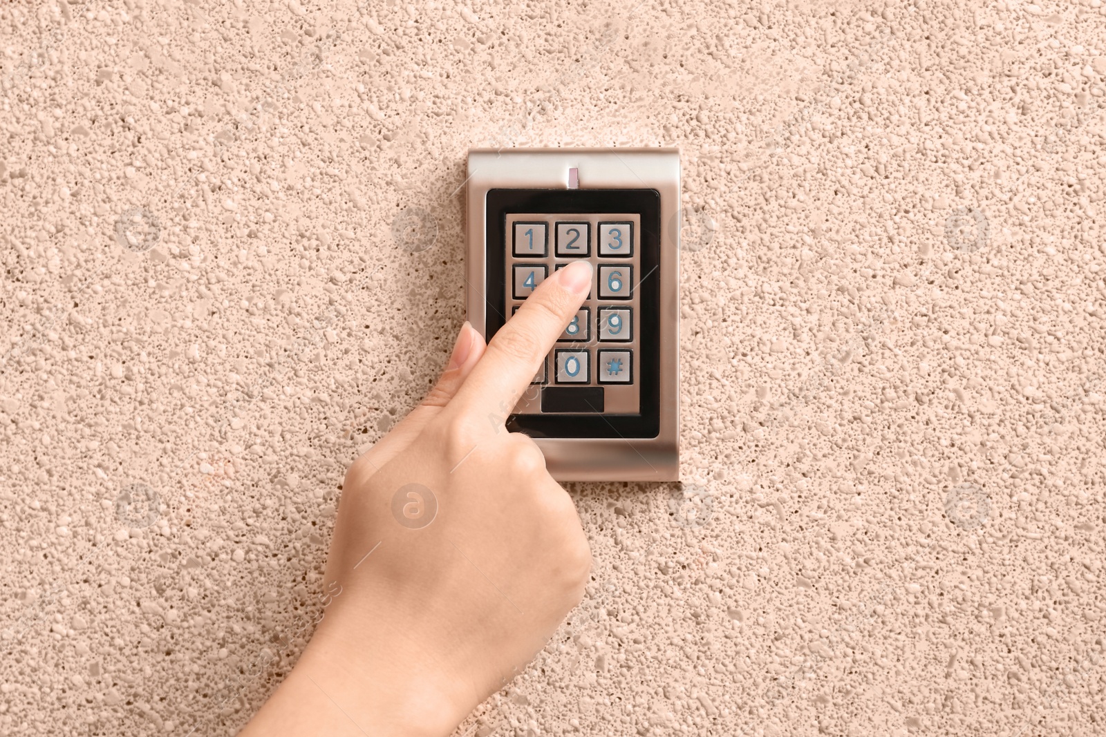 Photo of Woman entering code on electronic lock's keypad indoors, closeup