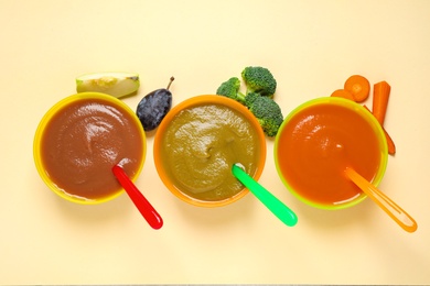 Healthy baby food and ingredients on yellow background, flat lay