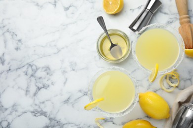 Photo of Delicious bee's knees cocktails and ingredients on white marble table, flat lay. Space for text