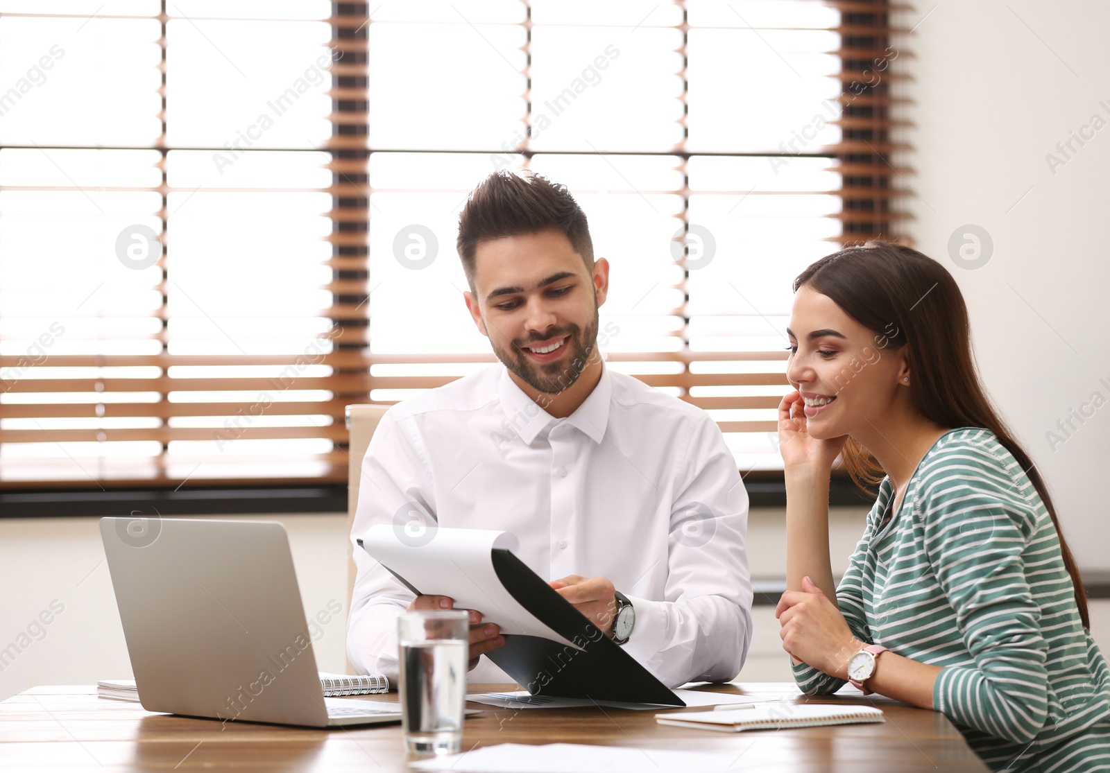 Photo of Insurance agent consulting young woman in office