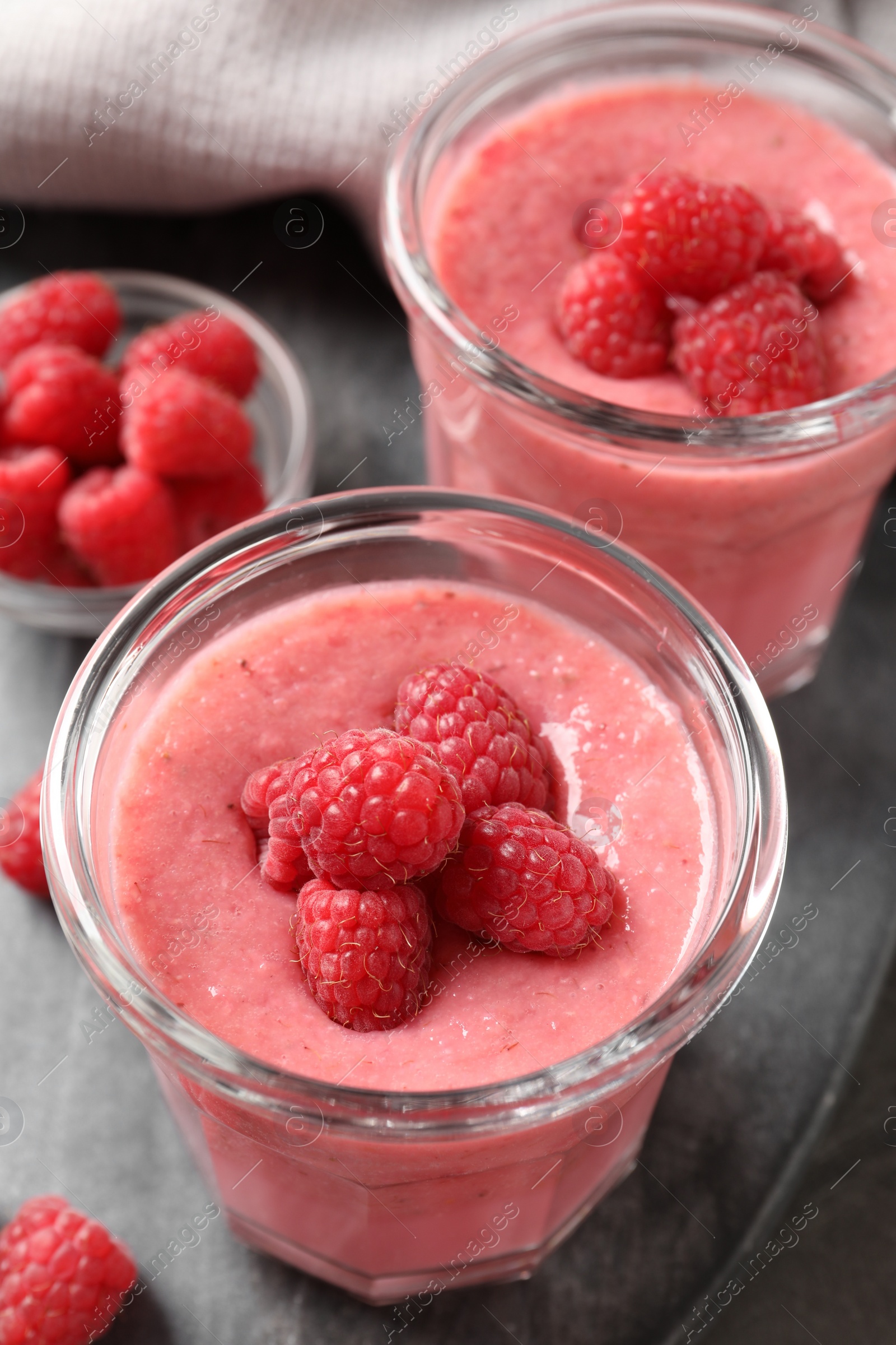 Photo of Delicious raspberry mousse served on grey table