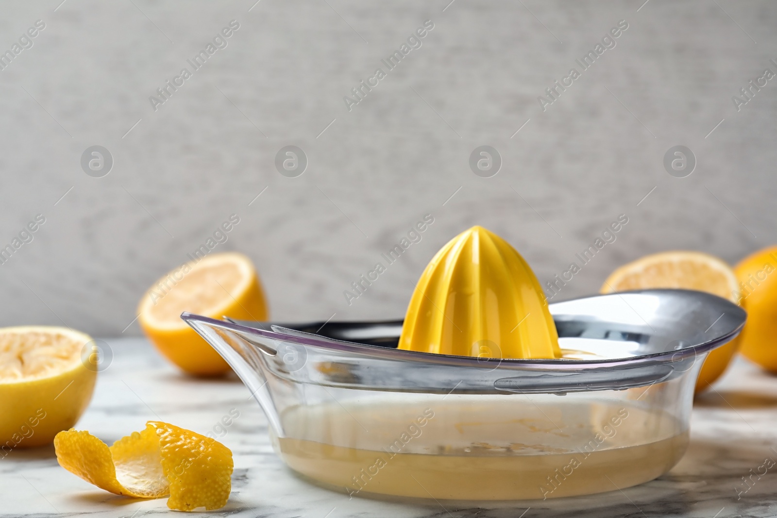 Photo of Lemon squeezer with fresh juice on table
