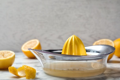 Lemon squeezer with fresh juice on table