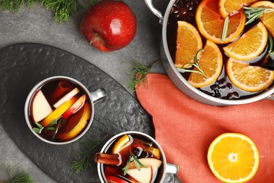 Tasty mulled wine with spices on grey table, flat lay