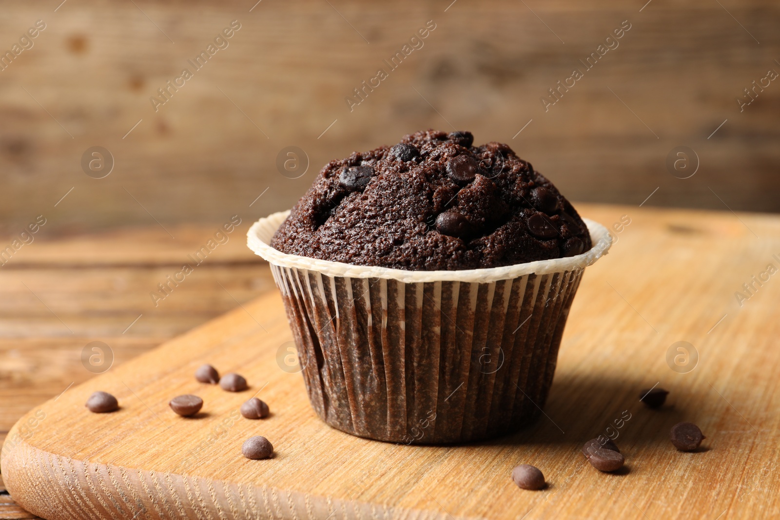 Photo of Tasty chocolate muffin on wooden table, closeup